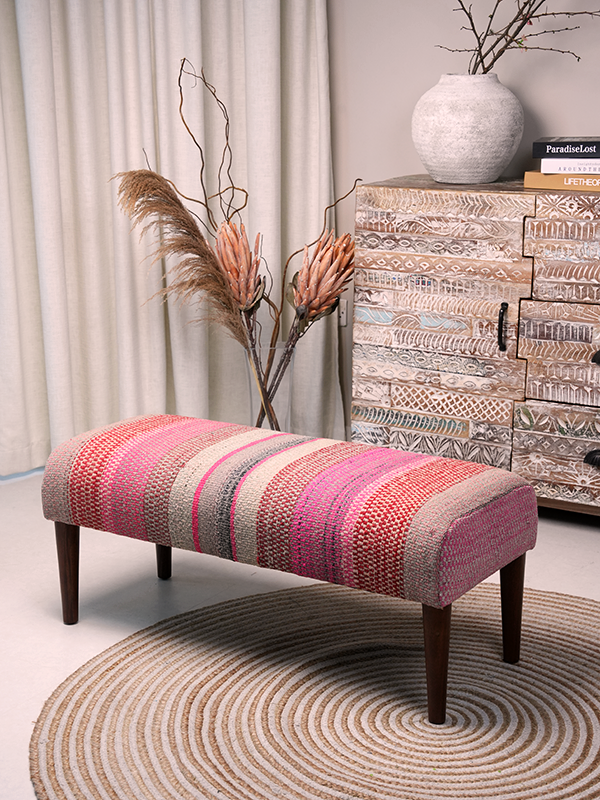 Full view of Frazada bench with striped patterns in shades of pink. Ideal for styling interiors and home decor purpose.