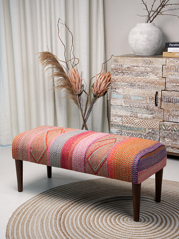 Full view of Frazada bench with striped patterns in pink and orange tones. Ideal for styling interiors and home decor purpose.