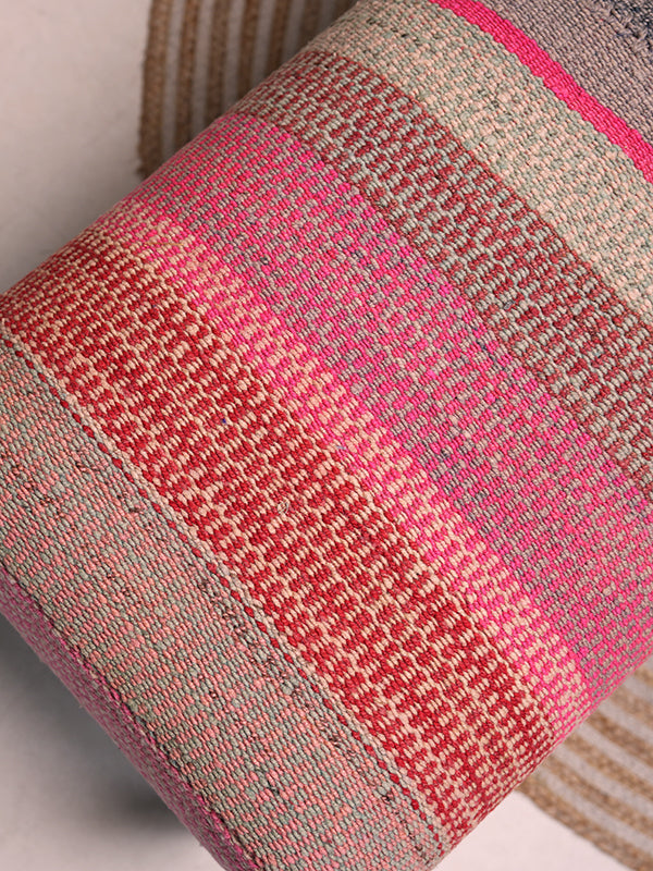 Close up shot Frazada bench with striped patterns in pink and orange tones. Ideal for styling interiors and home decor purpose.
