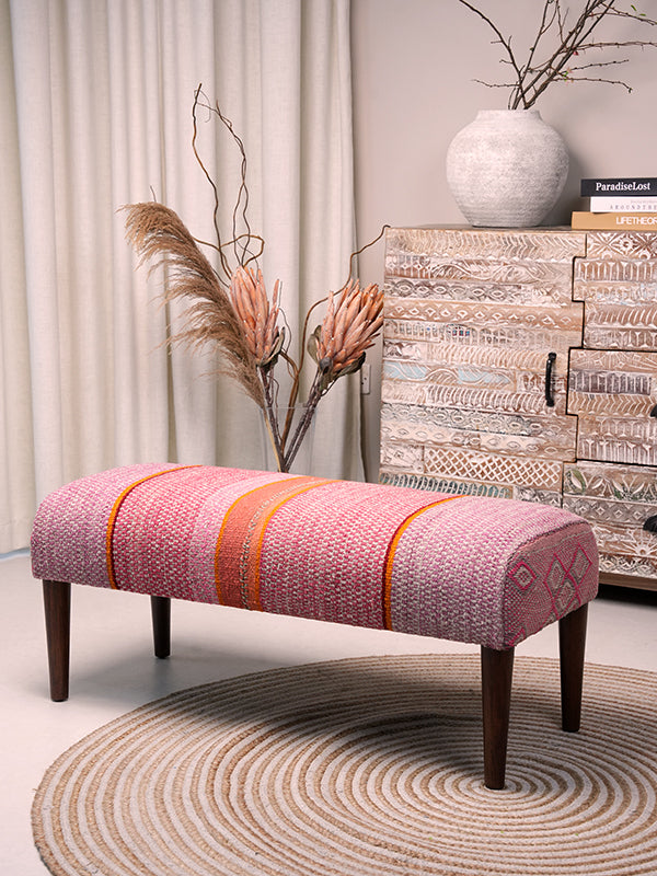 Full view of Frazada bench with striped patterns in pink and orange tones. Ideal for styling interiors and home decor purpose.